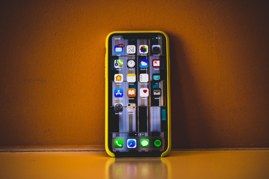 iPhone mobilni telefon, naslonjen ob steno